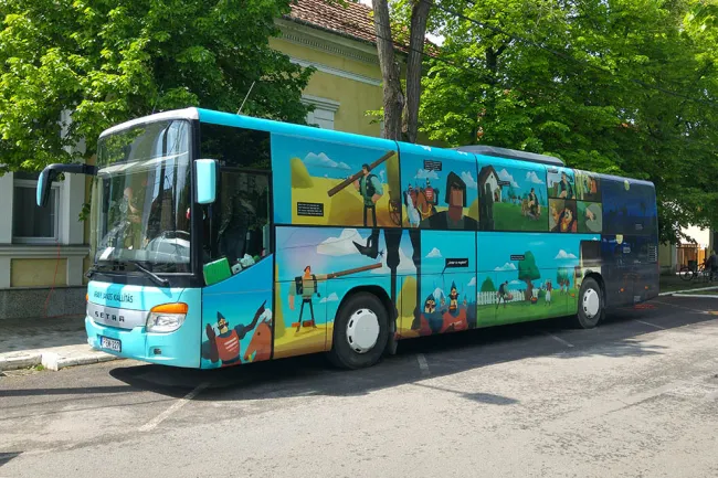 Arany-busz parkol a Határ Győző Városi Könyvtár előtt - (Az Arany-busz külsején a Toldi képeit láthatjuk)