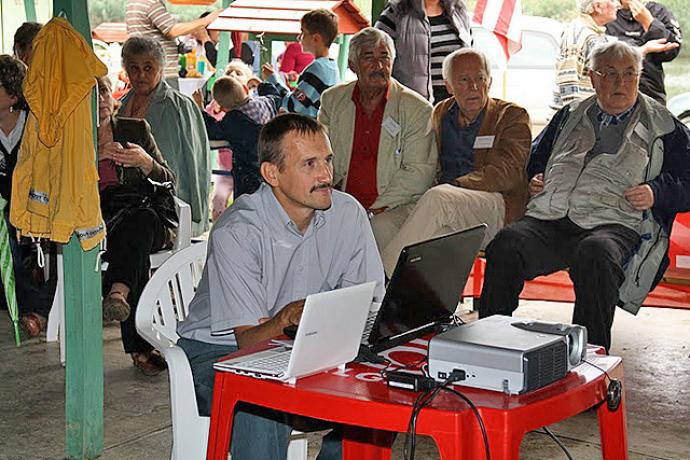Ugrin nemzetségi találkozó (A képen: Uhrin Gábor régi endrődi képeket vetít a háttérben: Ugrin Benő, Solymosi Frigyes, Ugrin Gábor)